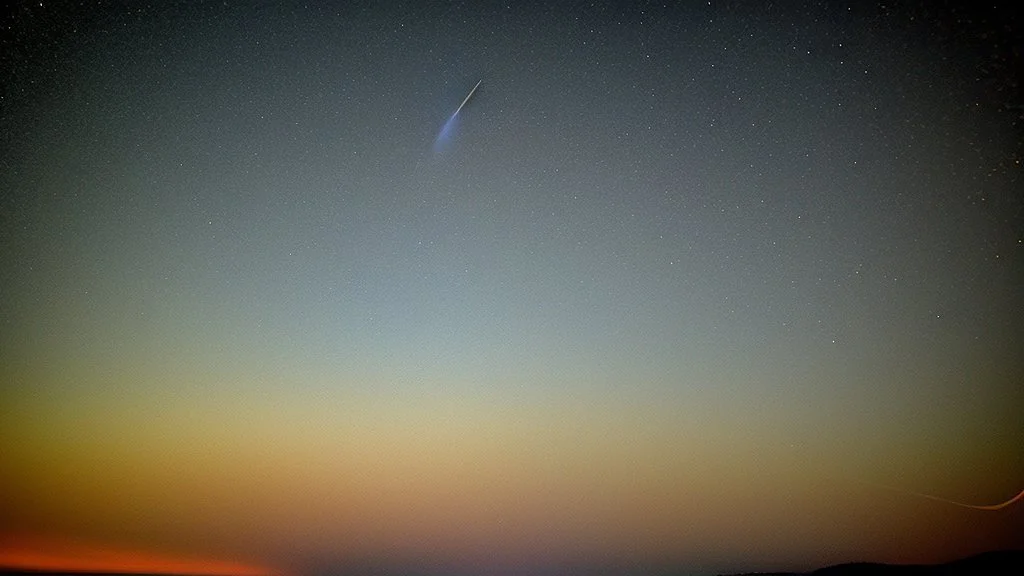 Comet in the night sky over the plain