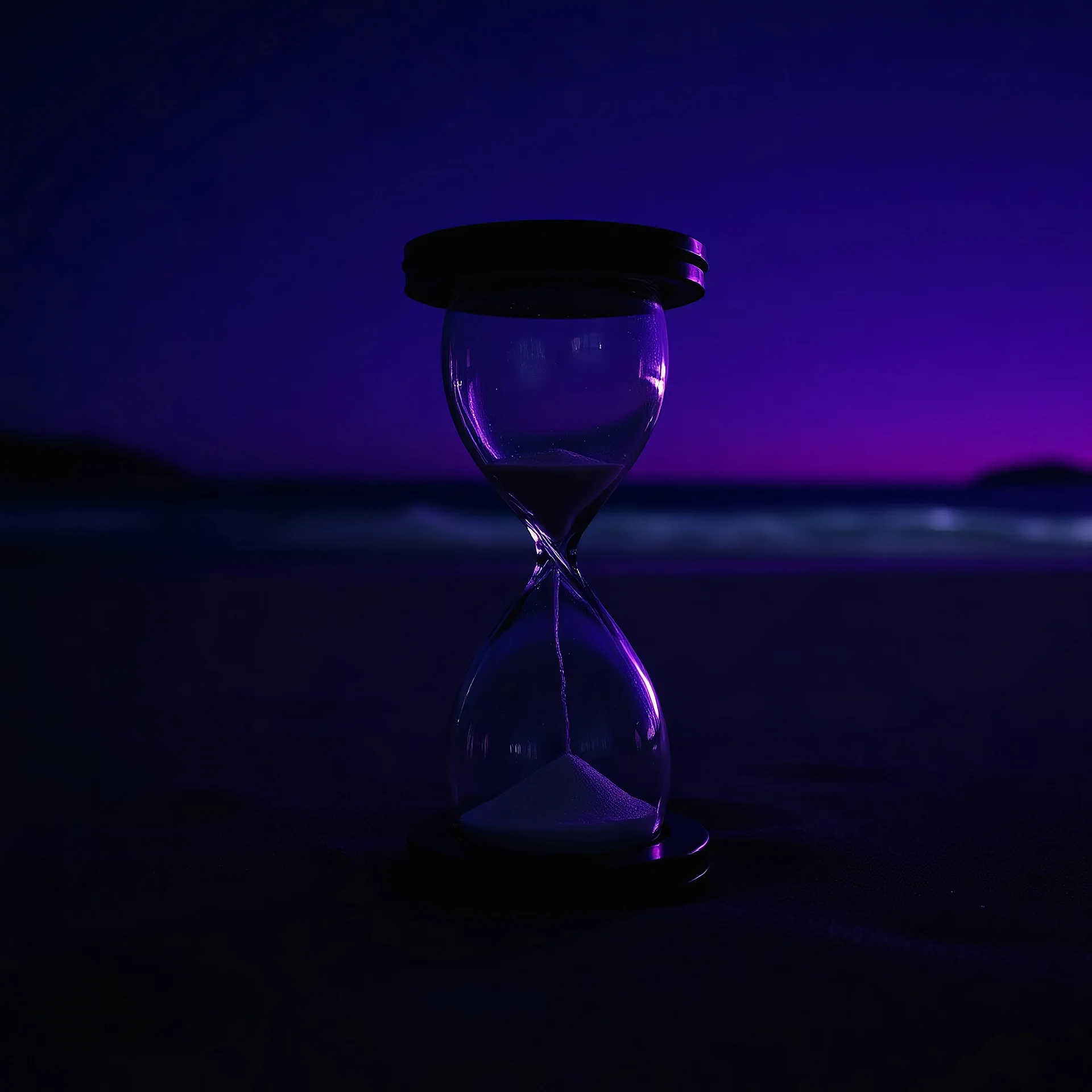 an hourglass on a beach at night, purple light