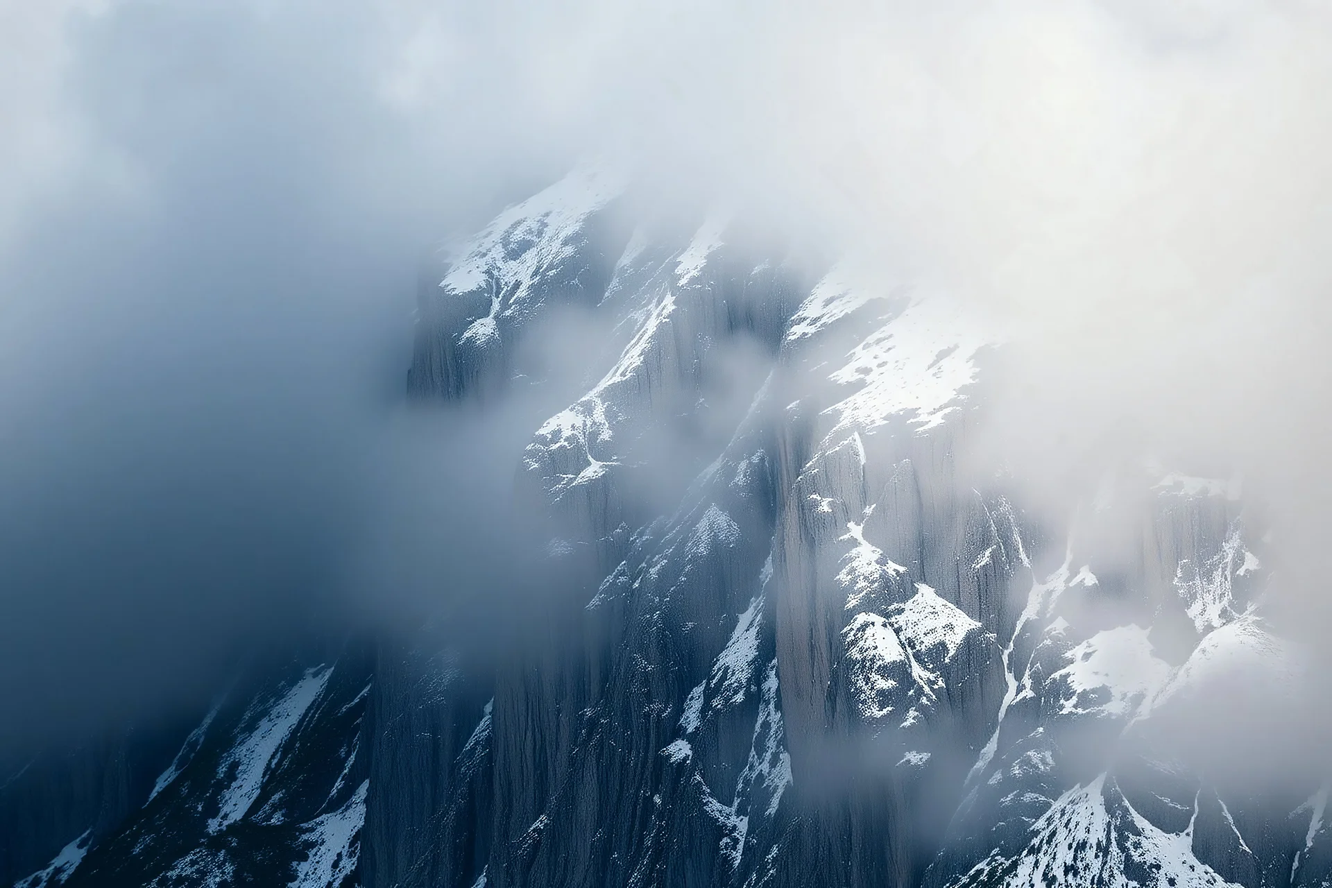 a massive sheer snowy mountain cliff with very sparse vegetation scaling vertically into the sky, partially obscured by dense clouds(color d0d1d5) and mist. the borders — top, bottom, left, and right — fade smoothly into thick fog, while the center reveals the steep, rocky cliff face with fine texture and detail. atmospheric lighting, cinematic composition, natural colors, high contrast between fog and stone. photography