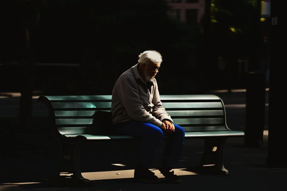 man sitting on a bench in the street