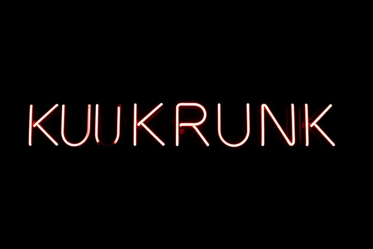 A simple neon sign labeled "KUKRUNK" black background