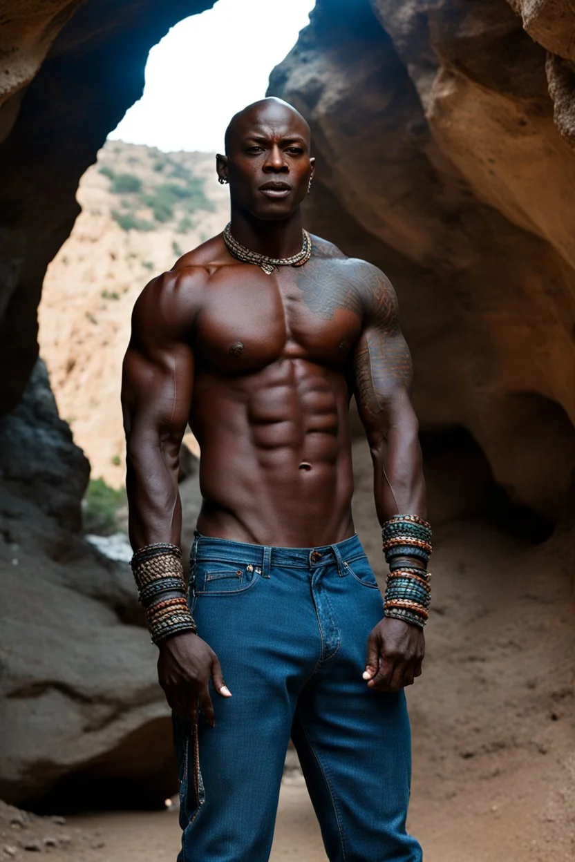 Alimi Ballard as very muscular male. bald with tribal tattoos wearing jeans and a teeshirt outside a cave