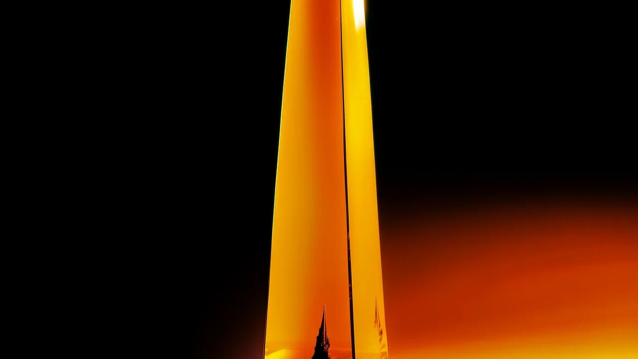 A yellowish orange colored crystal obelisk painted by Andy Warhol
