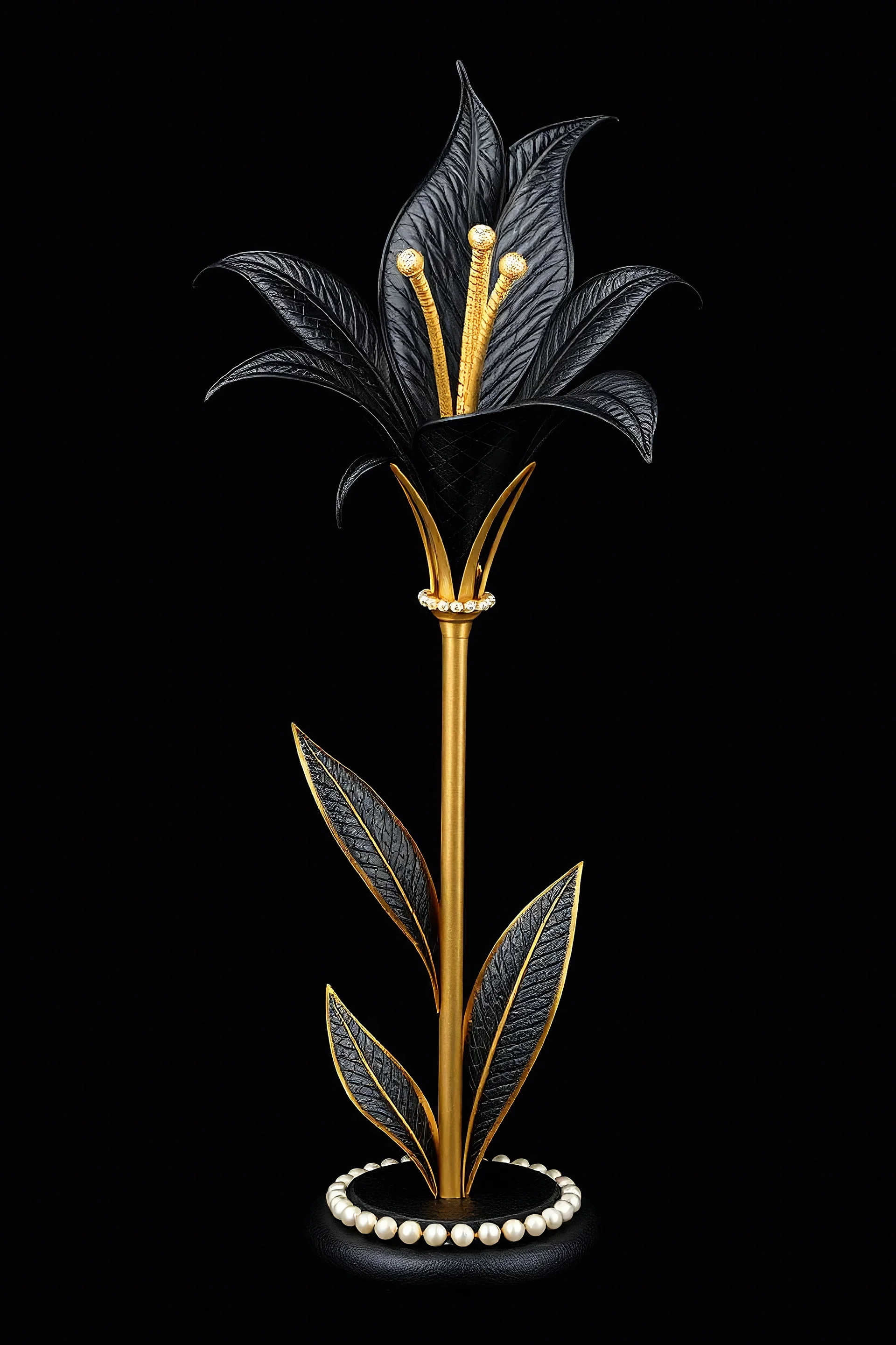 A tall lily made of black leather textures. The stem and leaves are gold-colored. Surrounded by pearls and diamonds. Background and base are black. The pattern is complete, stylish, and striking.