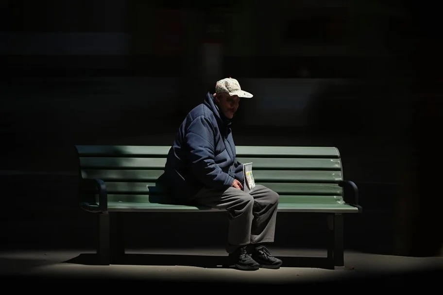 man sitting on a bench in the street