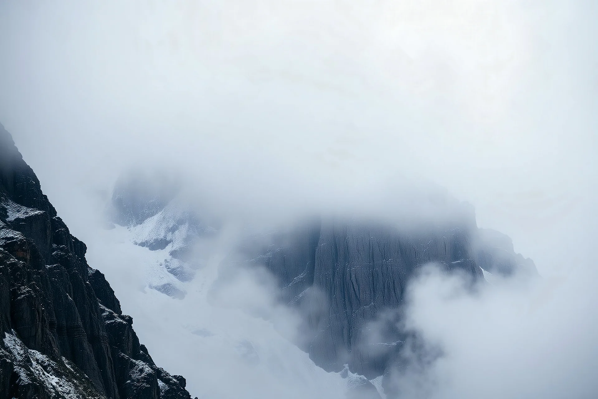 a massive sheer snowy mountain cliff with very sparse vegetation scaling vertically into the sky, partially obscured by dense clouds(color d0d1d5) and mist. the borders — top, bottom, left, and right — fade smoothly into thick fog, while the center reveals the steep, rocky cliff face with fine texture and detail. atmospheric lighting, cinematic composition, natural colors, high contrast between fog and stone. photography