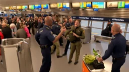 drunk pilot holding bottle of liquor gets confronted by crowd of travelers at airport