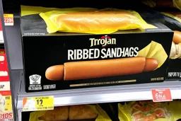 satirical product advertisement, Trojan brand black and gold sandwich bag box on display on a grocery store shelf, "RIBBED SANDWICH BAGS", picture on box is a long tubular hot dog bun poking out of an opaque yellow crenelated plastic bag, photorealistic, HD, natural lighting, Trojan brand logo