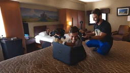 man plays fortnite with boy in hotel room