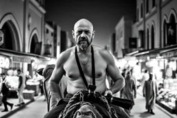 man looking like "Walter White" in breaking bad tv show, bald and goatee, with bare chest riding on a camel in a alley Casablanca town, panorama, black and white photo, lot of markets and people in background, camera in the back of him