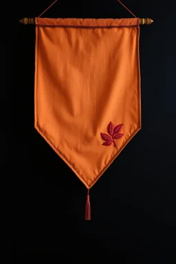 an autumn colored cloth banner hanging with embroidered leaves and slightly downward pointed bottom, on dark background