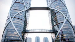 A pair of elliptical twin towers that intersect at various points along their height, creating a complex and beautiful pattern of interlocking curves. The towers are clad in reflective panels that highlight the gentle ellipses of the design. Walkways connecting the towers follow the arc, creating stunning vistas between the two structures. Award-winning photograph.