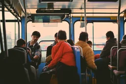 viajeros en el autobús urbano, fotografía realista, realizada con una cámra Fuji y un objetivo de 35 mm, atardecer