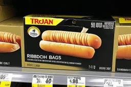 satirical product advertisement, Trojan brand black and gold sandwich bag box on display on a grocery store shelf, "RIBBED SANDWICH BAGS", picture on box is a long tubular hot dog bun poking out of an opaque yellow crenelated plastic bag, photorealistic, HD, natural lighting, Trojan brand logo