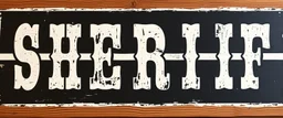 fill composition with large and wide historical hand painted old western sign that reads: "SHERIFF" white on black with inset white stripe boarder aged paint on wood sanserif