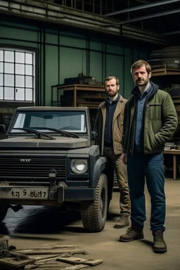 two haggard in their mid 30s looking men working in a land rover warehouse selling car parts