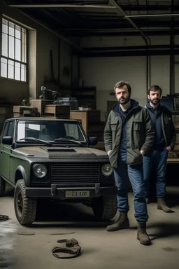 two haggard in their mid 30s looking men working in a land rover warehouse selling car parts