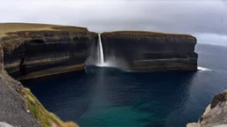 Fish-eye perspective from a climber's viewpoint on a high, sheer cliff face. Below, waterfalls cascade into a large, C-shaped cove or natural amphitheater at the base of the cliff. The cove is open to the turbulent ocean, with deep blue and turquoise water, crashing waves, and jagged rocks. Dark, striated cliff walls surround the cove. Overcast sky with diffuse, bright light. Photorealistic, 8k resolution, highly detailed, immense scale