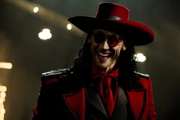 Still frame of Tom Hiddleston as Alucard from the live action "Hellsing" movie based on the anime of the same name. He is wearing his signature red hat and yellow glasses, while laughing in the moonlight.