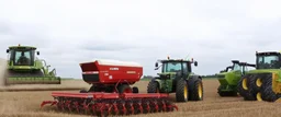 Parked at the edge of a field is a Claas brand Combine(left)seeder(middle) and a John Deere Tractor with seeder(right) simplified