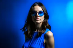 advertising photography, plain blue background, woman in blue dress, brunette, round sunglasses, real photography, 16K, shot with Leica camera, 35 mm lens, indirect lighting,