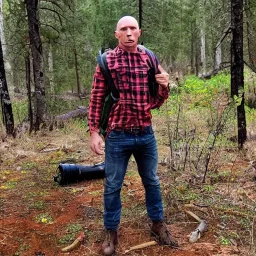 george st pierre bloody with a red plaid shirt a jean and a military backpack surviving in a forest while holding a rifle