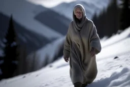 Una mujer mayor con la cara borrosa y mirada lateral, vestida con un camisón, camina sobre la nieve en un paraje de alta montaña. Fotografía con cámara Leica y objetivo de 35 mm. Fotografía en Blanco y Negro