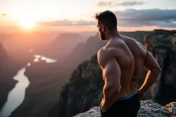 a muscular man views sunset from a cliff