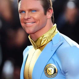 A superhero man with a sky blue spandex suit. He has a sky blue mask on, blue eyes, freckles, dimples, and curly dark brown hair. He's wearing gold boots and gold artist gloves with a white belt and has a gold M on his chest. His boots have small feathered wings on them, and his shoulders have shoulder pads. He is smiling