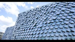 Kinetic façade of a museum, made of thousands of steel and glass scales that shift with the wind.
