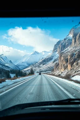 surreal mountain road seen through a dirty truck front window, dirty blue snow and wind
