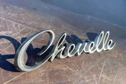 "Chevelle" nameplate 3d metal with shadow, on top of scratched wood surface