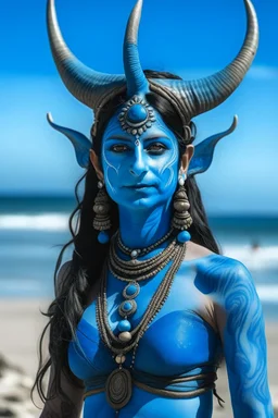 A photo of a blue skin Hindu goddess with painted blue face and body skin, wavy black hair deer antler horns, standing on a sunny beach