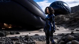 A woman in a catsuit standing on a beach of a rocky landscape with a crashed spaceship in the distance