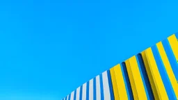 A modern, minimalist architectural scene with geometric shapes and patterns. The image features a blue sky background, a yellow horizontal band, and a series of vertical blue and white stripes or panels.