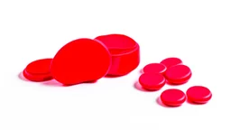 a bubble pack of red pills, next to torn red ribbon, on a white background
