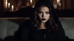 [Legend (1985)] Danielle Campbell as Dahlia Death, she is a pale brunette with black lipstick clad in a dark agent provocateur dress with a hoodie and a scythe. She sits on a sofa in a dark mansion