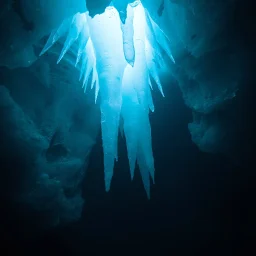 a dark frozen underwater cave, ice crystals, dimly lit