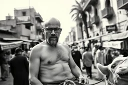 man looking like "Walter White" in breaking bad tv show, bald and goatee glasses, with bare chest riding on a camel in a alley Casablanca town, panorama, black and white photo, lot of markets and people in background