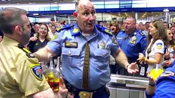 drunk pilot holding bottle of liquor gets confronted by crowd of travelers at airport