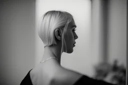 Mujer rubia de espaldas, retrato primer plano., iluminada desde desde el rostro hacia la cámara, Imagen en blanco y negro vaporoso, al estilo de la foto del fotógrafo Hugo Alonso.