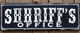 fill composition with large and wide historical hand painted old western sign that reads: "SHRIFFS OFFICE" white on black with inset white stripe boarder aged paint on wood sanserif