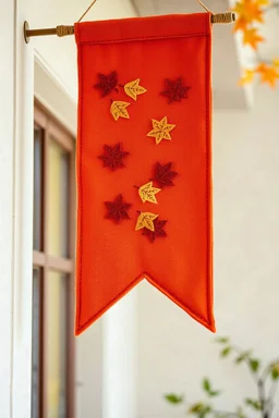 an autumn colored cloth banner hanging with embroidered leaves and slightly pointed bottom