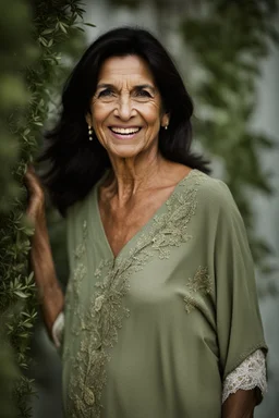 Portrait of a 60 year old Olive skinned woman, dark hair with hints of grey, happy expression