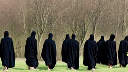 Black robed, hooded monks in the field