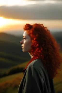кудрявая рыжая девушка стоит на холме спиной к нам и смотрит на закат солнца