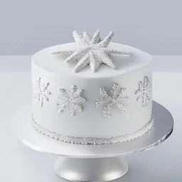 A picture of a simple white cake with silver decoration