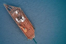 Aerial view of wooden ship sinking, flir camera, night vision, helicopter view, drone pov, night, ship sinking