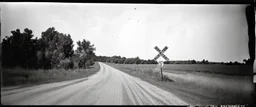 old wester railroad crossing a dirt road , grayscale, antique photo