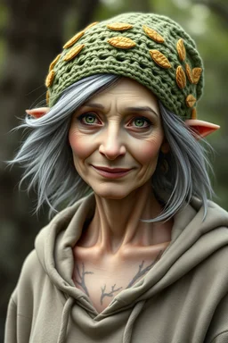 Generate a dungeons and dragons character portrait of the face and torso of an old female spring Eladrin. She looks ordinary. She wears a dainty green crochet beanie with gold coated leaves on it, and a loose fitting hoodie sweatshirt. Her hair is grey and flowing, her skin pale. Her eyes are sage. She has branches tattooed on her collar bones. She is smirking. It is important to give her face wrinkles. Her ears slightly show. Add a nature background. Make it look like an old photograph.